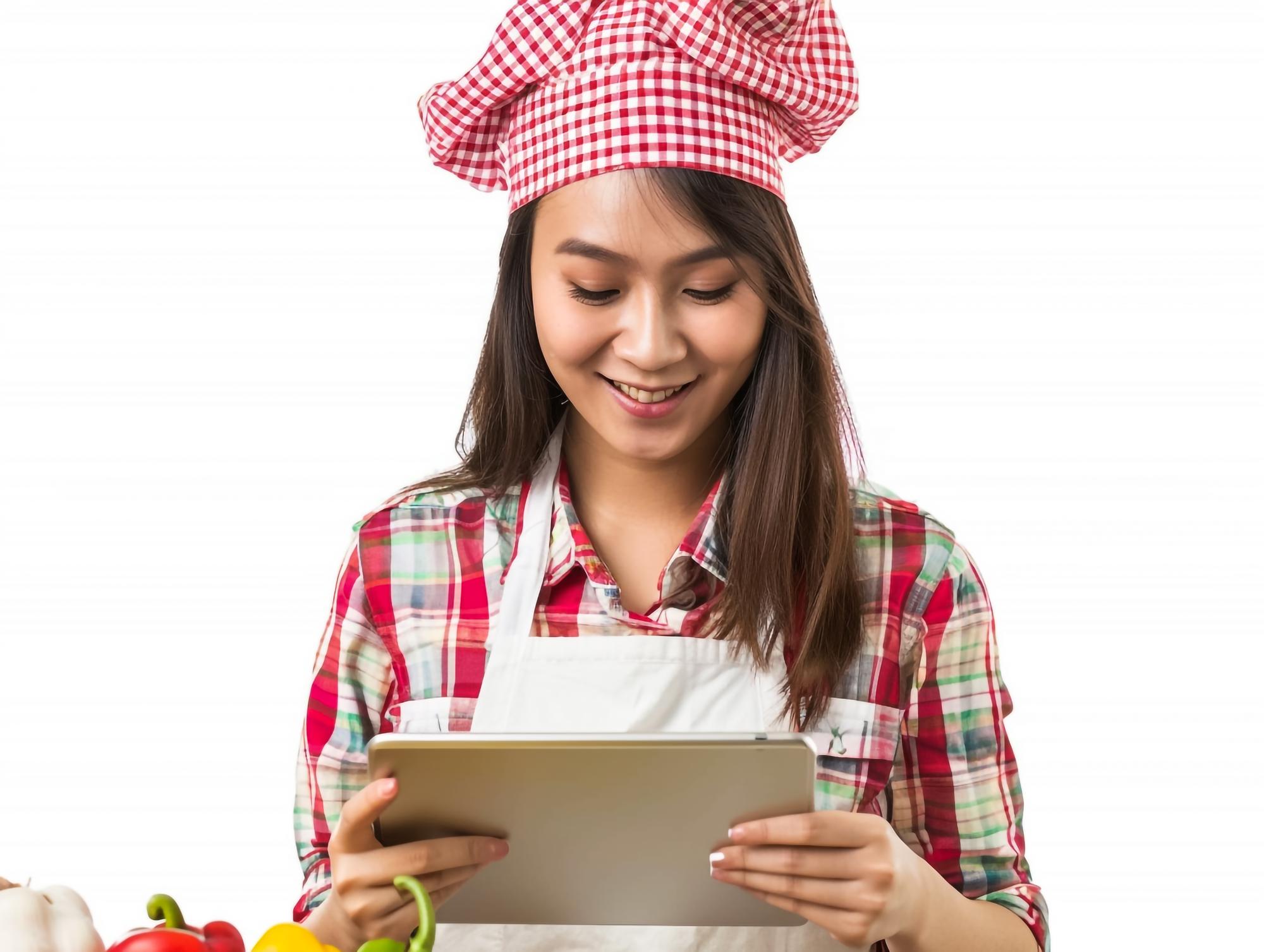 Studente che segue le istruzioni su tablet in cucina